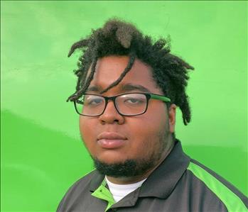 Crew member Tevin with a green background